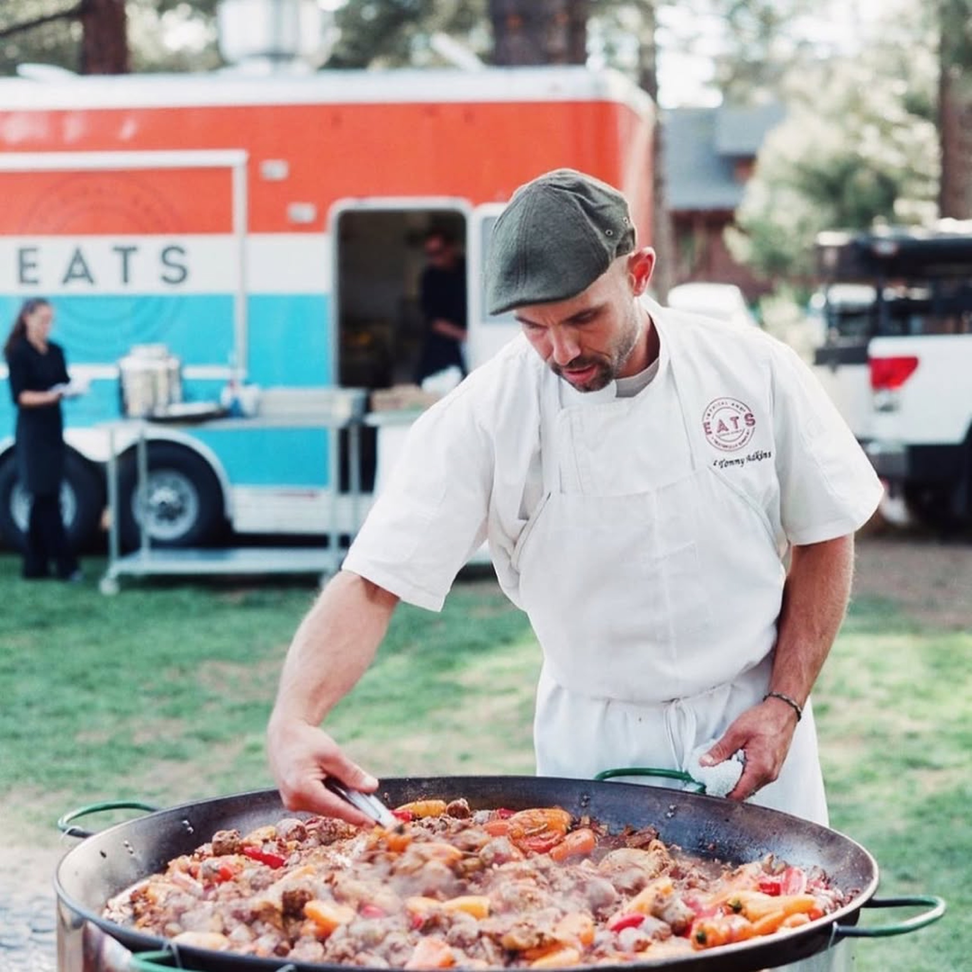 Chef Tommy cooking paella beside the truck